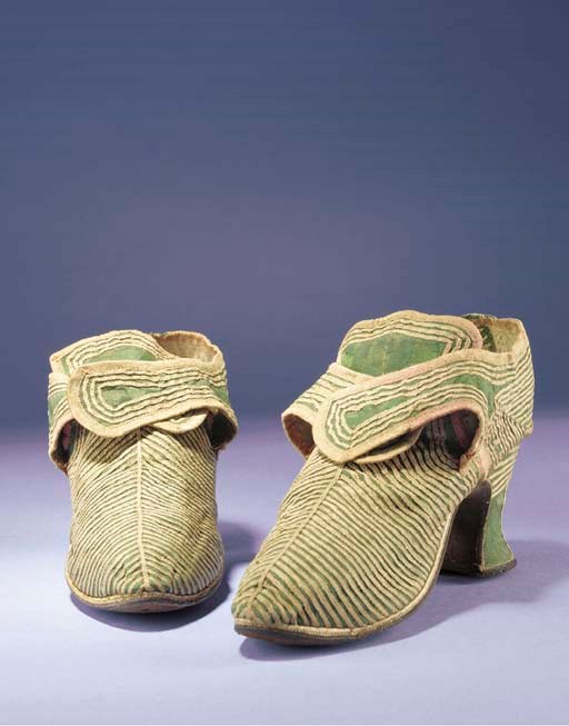 A pair of lady's shoes, of moss green silk damask applied with narrow strips of pink braid in angular form, with high tongue, buckle straps, the toes with rounded point, with white kid rand and covered 2½in. (6cm.) heel, English, circa 1730