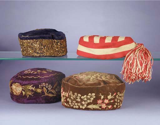 A smoking cap, of royal blue velvet worked with Indian embroidery of gold metal thread, purl and spangles, late 19th century; two embroidered velvet smoking caps; and a cap of red and white striped facecloth with matching tassel, the interior inscribed in ink J M Pets Dec 21st 1912