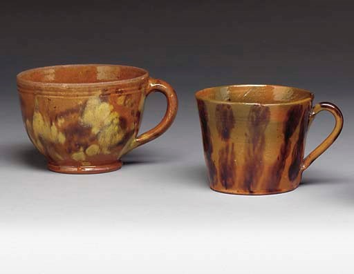 A GROUP OF TWO GLAZED REDWARE HANDLED CUPS