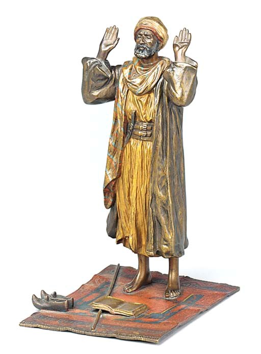 A COLD PAINTED BRONZE FIGURE OF A MAN AT PRAYER