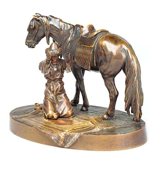 A COLD PAINTED BRONZE GROUP OF A RUSSIAN COSSACK AT PRAYER