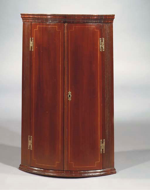 An English mahogany and fruitwood hanging corner cupboard