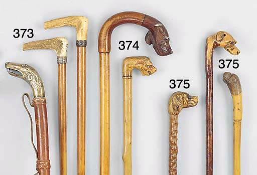 A carved fruitwood mounted gnarled wood walking stick
