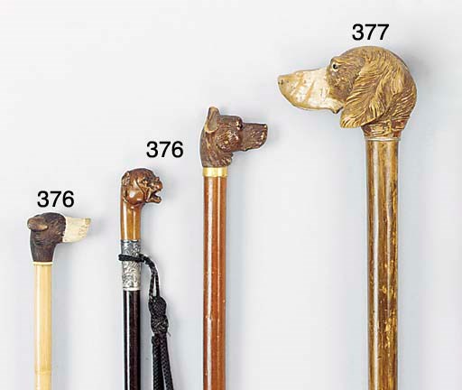A carved fruitwood and silver mounted hardwood walking stick