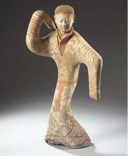 A painted grey pottery figure of a dancer