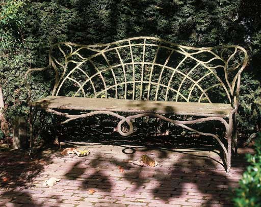 A WHITE-PAINTED CAST-IRON GARDEN BENCH