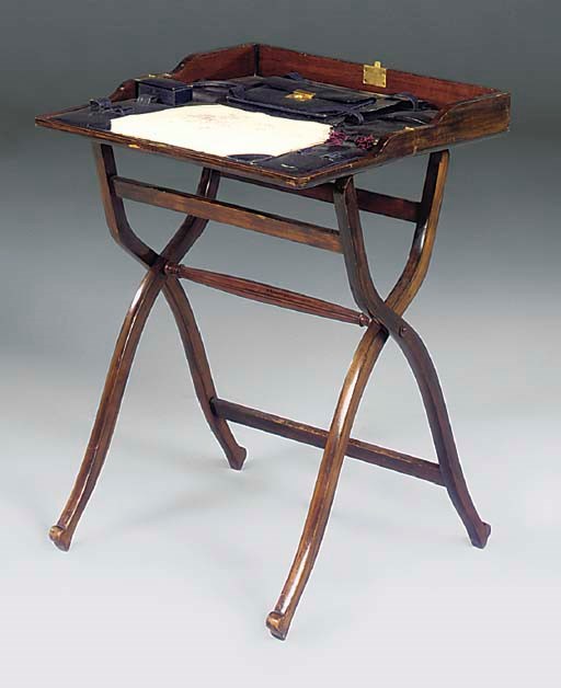 AN EDWARDIAN STAINED WALNUT FOLDING WRITING TABLE