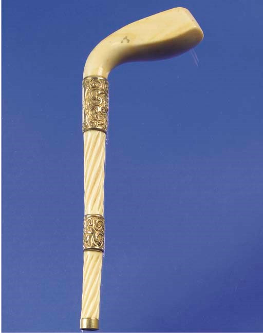 AN IVORY AND YELLOW-METAL MOUNTED WALKING CANE HANDLE