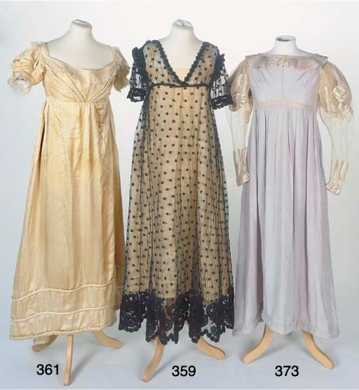 A lady's Empire line evening dress of embroidered black net, embroidered in black chenille and applied with black silk immitating black blonde lace, with scattered floral spot motifs, the scalloped hemline applied and embroidered with clusters of stylised carnations, the ankle-length gored skirt falling from a high waist, the bodice with deep-V neck and short sleeves trimmed with later black satin ruffle to the shoulders, the slip of pale yellow silk crêpe finished with a padded hem, circa 1820, some damages and repairs