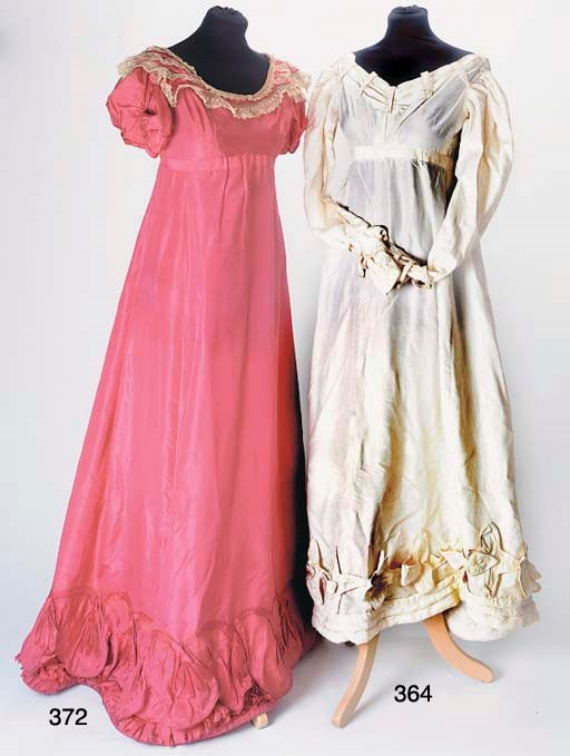 A lady's evening gown of coral red silk, the high-waisted bodice with wide neck and short puffed sleeves, the gored skirt with padded ruffled hemline, trimmed with a scalloped flounce edged with piping and applied with a stylised meandering vine border bearing quatrefoil flower motifs, with similar motifs applied to the sleeves, the wide neckline trimmed with mechlin-type lace, circa 1830, some stains