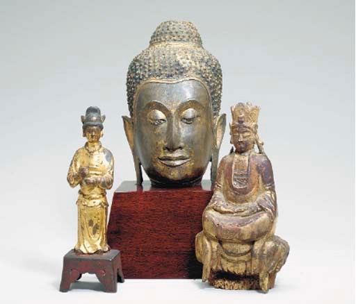 A THAI GILT-BRONZE HEAD OF BUDDHA TOGETHER WITH A SOUTHEAST ASIAN GILT-WOOD FIGURE OF A SEATED BUDDHA     DHA WITH A BRONZE HEAD OF BUDDHA