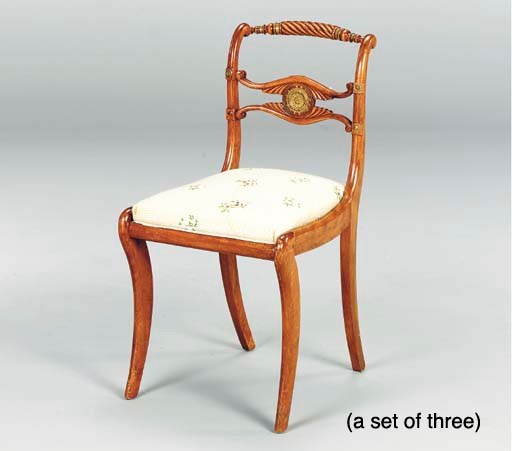 A SET OF THREE REGENCY CARVED FRUITWOOD AND GILT METAL MOUNTED SIDE CHAIRS,