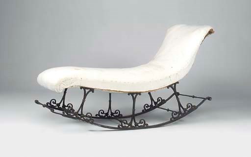A WROUGHT AND CAST IRON ROCKING CHAISE