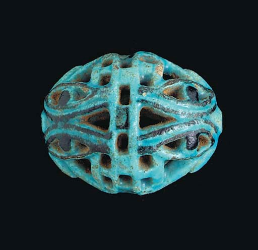 AN EGYPTIAN FAIENCE OPENWORK WADJET-EYE BEAD