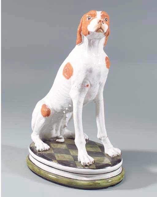 A MAJOLICA MODEL OF A SEATED HOUND,