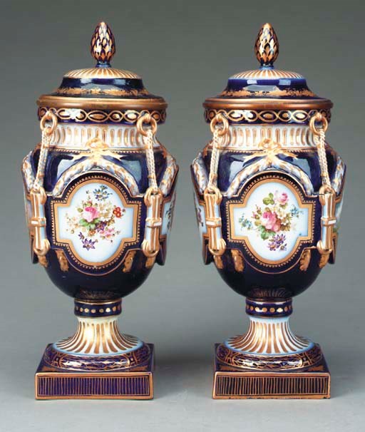 A PAIR OF SEVRES STYLE COBALT BLUE GROUND PORCELAIN COVERED URNS,