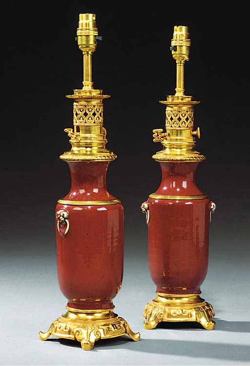 A PAIR OF GILT BRONZE AND SANG DE BOUEF PORCELAIN TABLE LAMPS