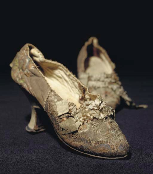 A pair of lady's shoes, the snuff ground brocade woven with flowers and trimmed with ruched blue ribbon, the vamps with scallopped leather trim, lined with white kid, with white kid angular heels--8cm high, second half of the 18th century, binding defective