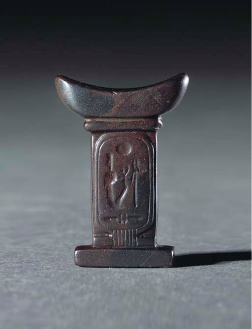 AN EGYPTIAN BROWN HAEMATITE ROYAL AMULET IN THE FORM OF A HEADREST