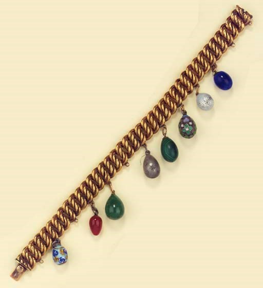A GOLD BRACELET WITH EIGHT EGG PENDANTS
