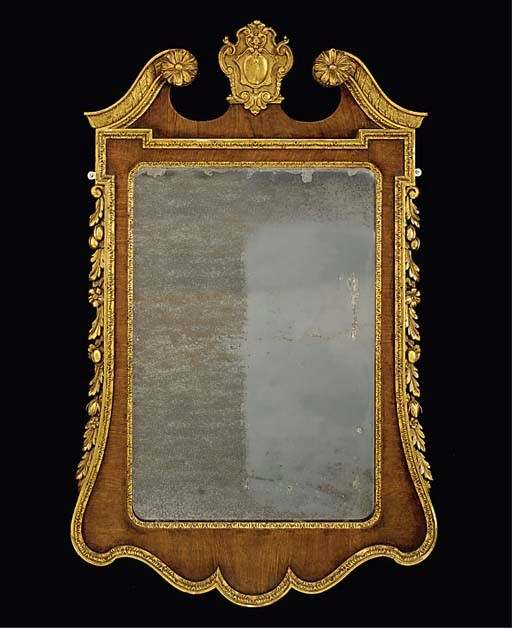 A WALNUT AND PARCEL GILT WALL MIRROR