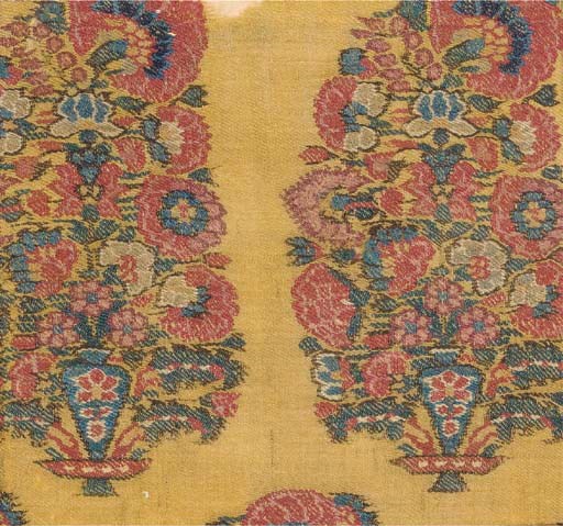 A long jamawar shawl of mustard yellow wool, finely woven with a field of delicate flowering vines and pallus of nine upright millefleurs boteh, the lateral borders and gallery with smaller slanting boteh--123 x 56in. (312 x 142cm.), Kashmir, 19th century