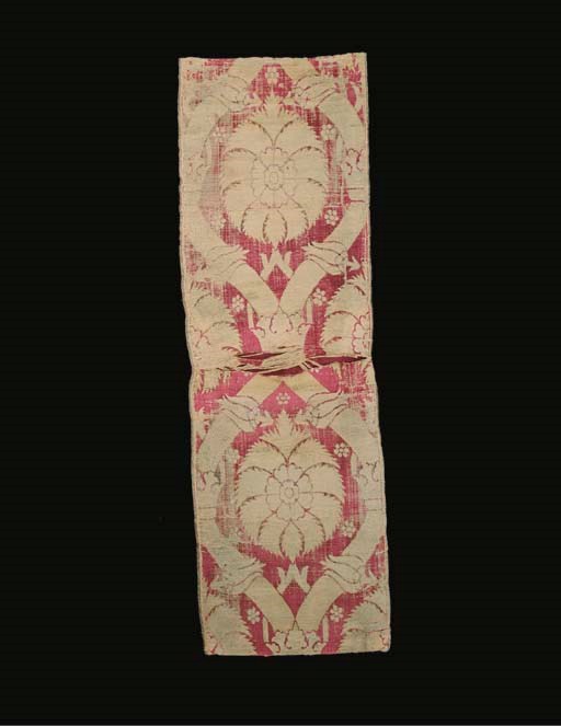 A length of crimson voided velvet, woven with an ogival lattice with crowns at the interstices, centred with large-scale palmettes flanked by paired tulips--77 x 24in. (196 x 61cm.), Ottoman, late 16th/early 17th century, wear, slits and extensive machine couched repairs