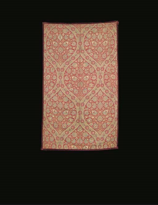 A panel of crimson silk brocade, finely woven in metal thread and blue and ivory silks with a floral ogival lattice enclosing formalised bouquets of palmettes, pomegranates and small flowers--43½ x 26in. (110 x 66cm.), Ottoman, 17th century, with later backing and velvet bindings