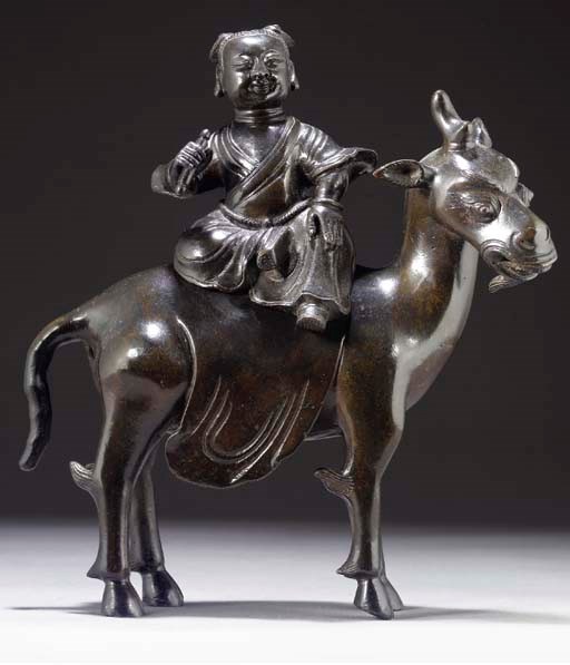 A Chinese bronze model of a boy seated on a one-horned mythical beast, late Ming Dynasty