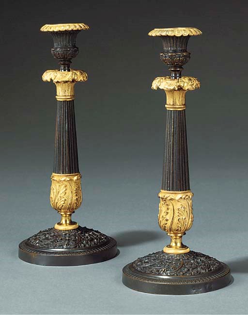 A pair of French gilt and patinated bronze candlesticks