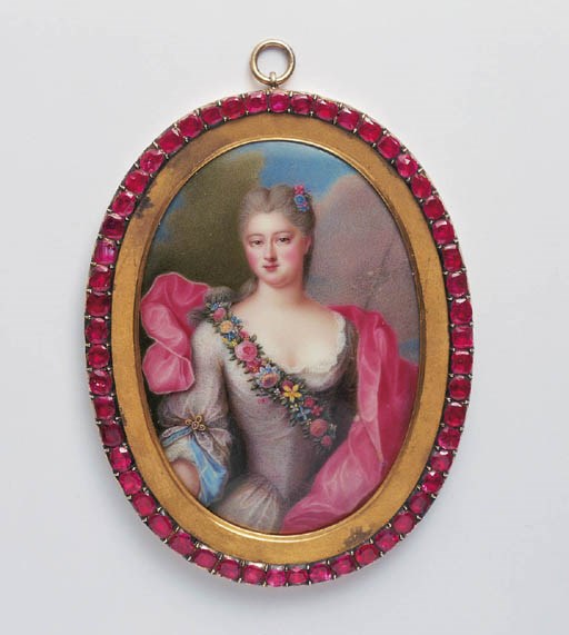 AN ENAMEL MINIATURE OF A LADY IN A RUBY SET FRAME