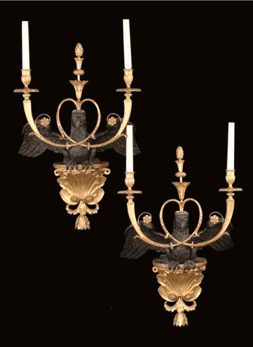 A PAIR OF NORTH EUROPEAN EBONISED AND GILTWOOD TWO-LIGHT WALL-LIGHTS