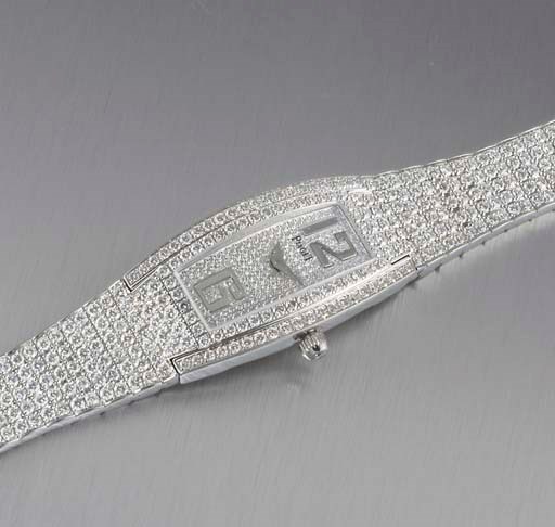 PIAGET. A LADY'S 18K WHITE GOLD AND DIAMOND-SET TONNEAU-SHAPED WRISTWATCH WITH BRACELET