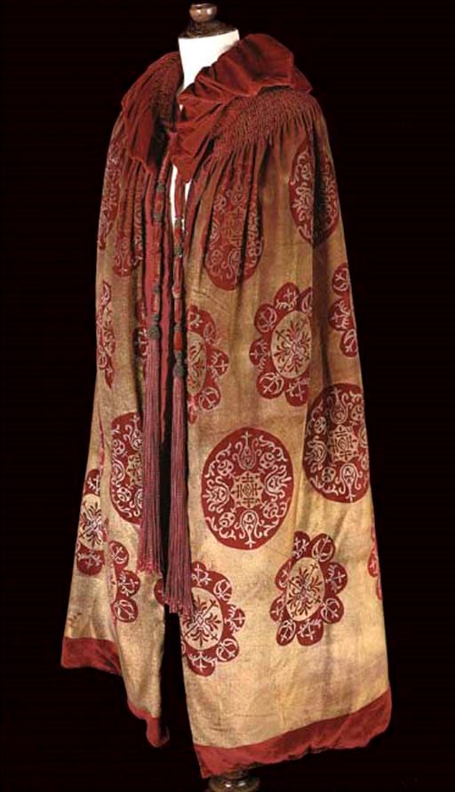 A RED AND GOLD VELVET OPERA CAPE, PROBABLY GALLENGA