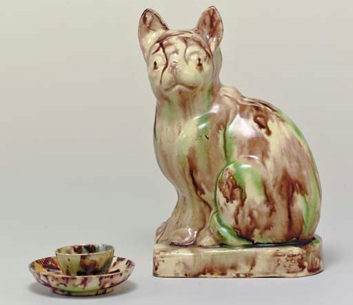 A STAFFORDSHIRE CREAMWARE MODEL OF A CAT