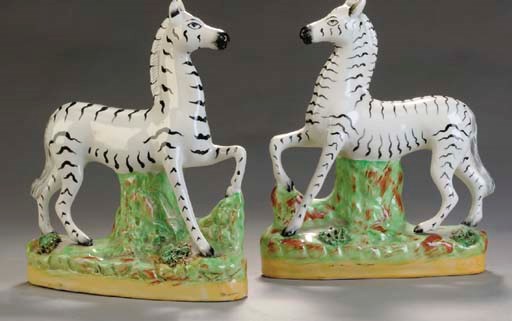 A PAIR OF STAFFORDSHIRE MODELS OF ZEBRAS,