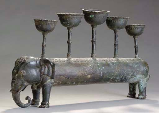 AN EASTERN STYLE PATINATED BRONZE ELEPHANT-FORM FIVE-LIGHT CANDELABRUM TOGETHER WITH A PATINATED BRONZE FIGURE OF A SNAKE,