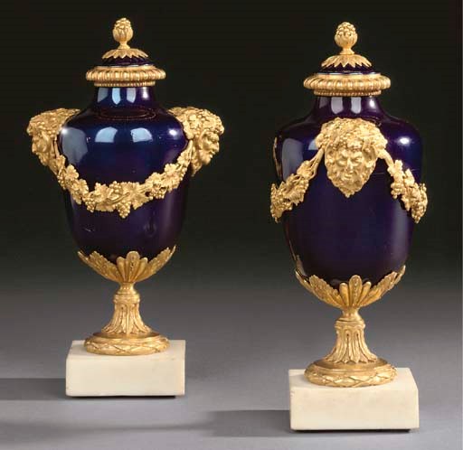 A pair of Louis XVI style ormolu-mounted blue enamelled vases and covers