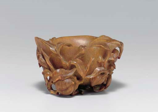 **A FINELY CARVED PEACH-FORM RHINOCEROS HORN LIBATION CUP