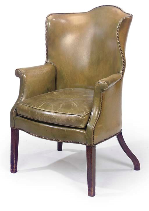 A GEORGE III GREEN LEATHER UPHOLSTERED WING ARMCHAIR
