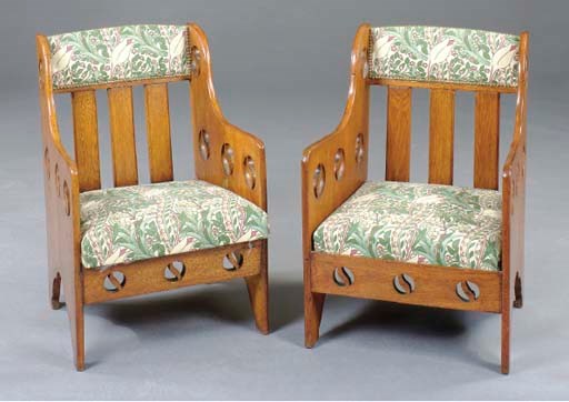A PAIR OF ARTS AND CRAFTS PIERCED CARVED OAK UPHOLSTERED ARMCHAIRS,