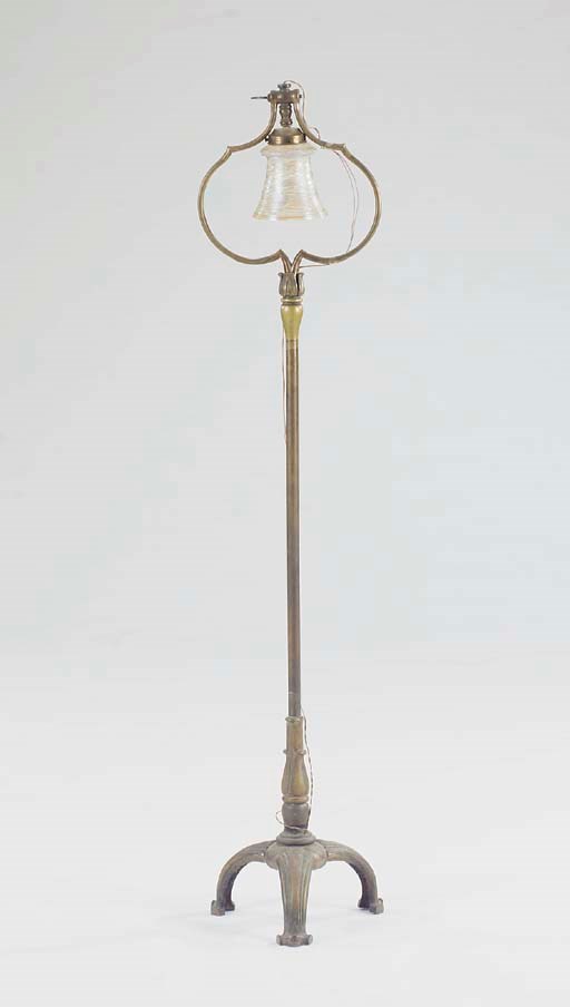 A PATINATED BRONZE FLOOR LAMP WITH A GLASS SHADE,
