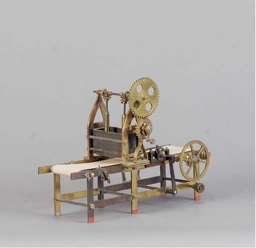 A BRASS MINIATURE MODEL OF A SNAP MACHINE,