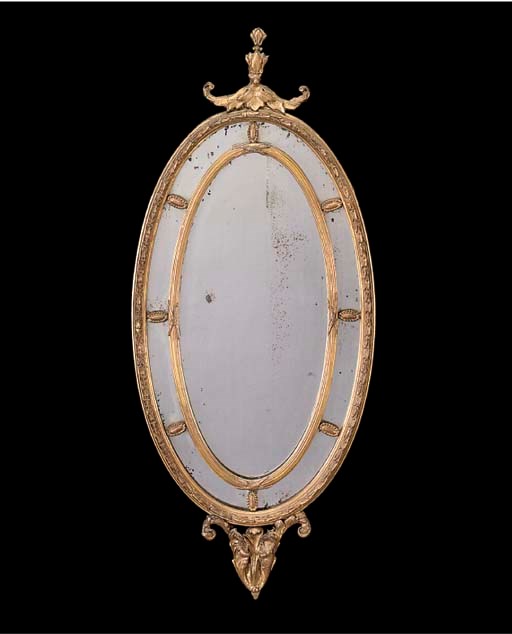 A GILTWOOD AND COMPOSITION OVAL MARGINAL MIRROR
