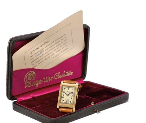 A. Lange & Söhne. A 14K gold rectangular curved wristwatch with original guarantee and box