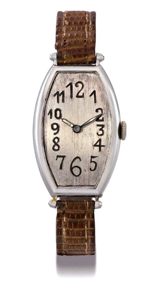 Audemars Piguet. An unusual and early platinum tonneau-shaped hinged curved wristwatch