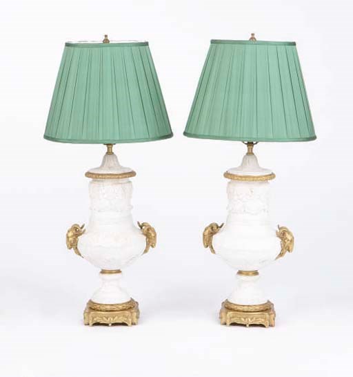 A PAIR OF CONTINENTAL BISCUIT PORCELAIN AND GILT-BRONZE MOUNTED URNS CONVERTED TO TABLE LAMPS,