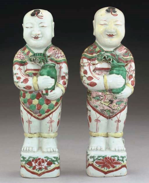 A pair of chinese famille verte standing boys, 18th Century