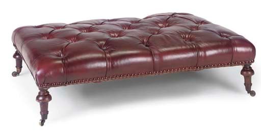 A LARGE RED LEATHER UPHOLSTERED CENTRE STOOL