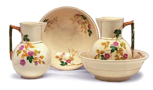 TWO POTTERY PART BEDROOM SETS MOULDED AND PAINTED WITH FLOWERS